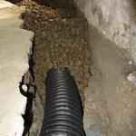 Laying the drainage pipe, and covering with river gravel.